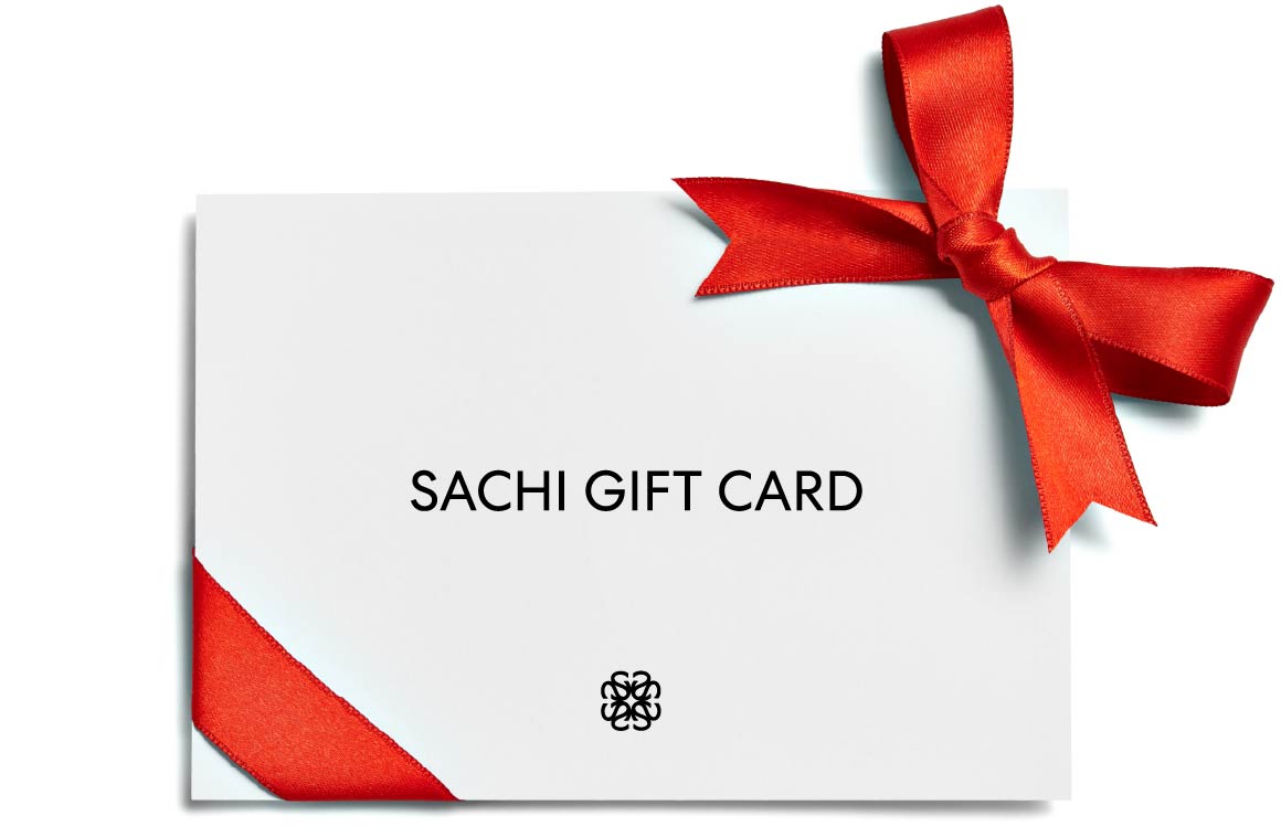A white gift card with the SACHI brand logo, wrapped with a red ribbon bow at the top, with the text 'SACHI GIFT CARD' displayed prominently in the center.
