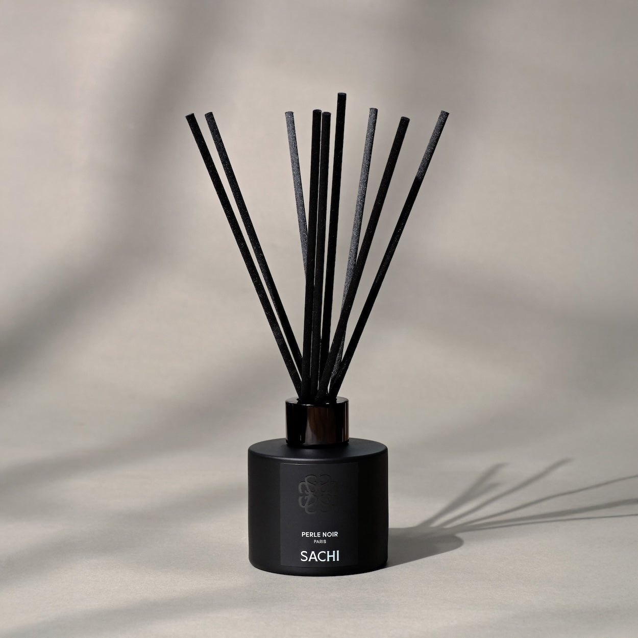 Black Perle Noir diffuser with reeds on a neutral background