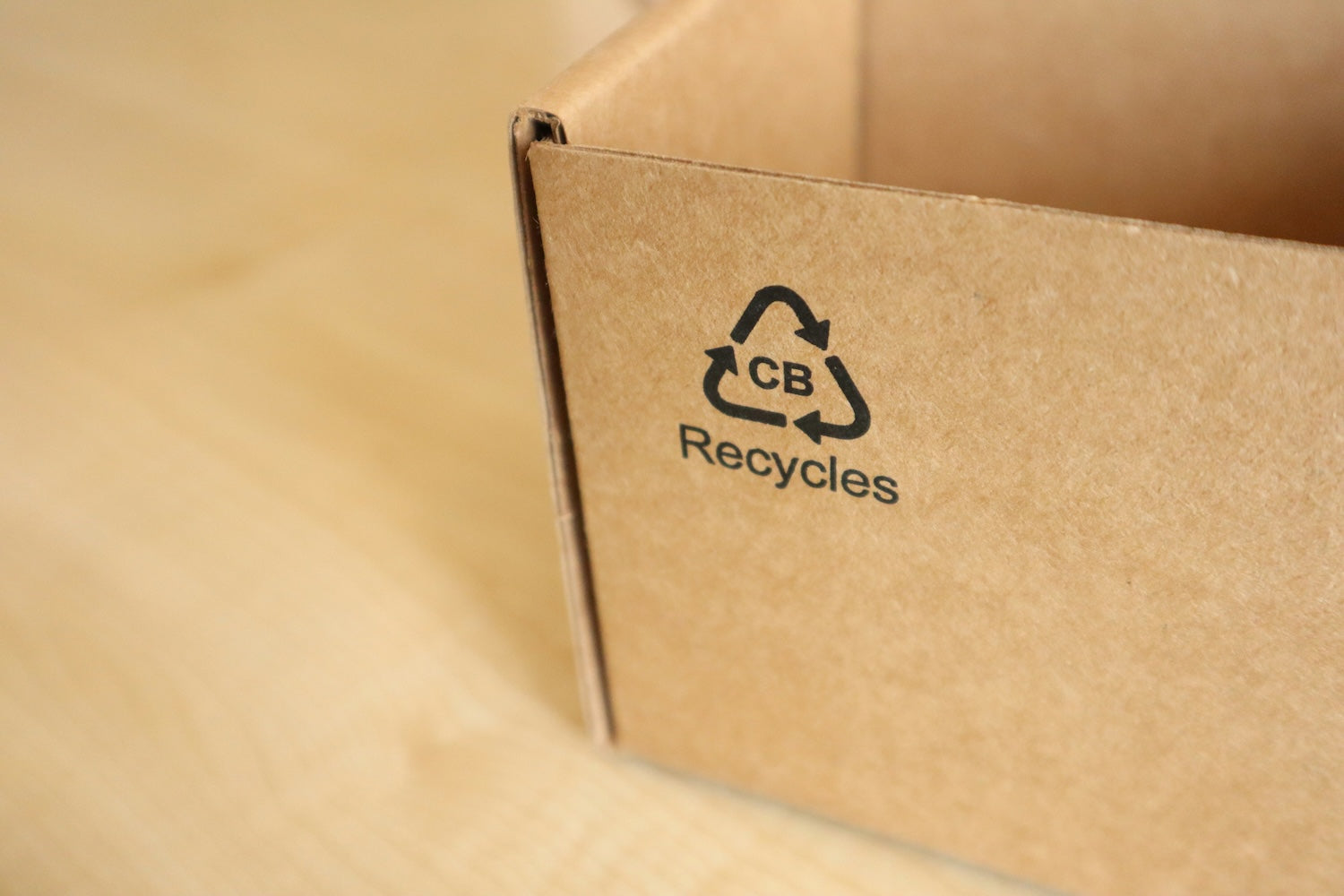 Close up of a recycle logo on a cardboard box.