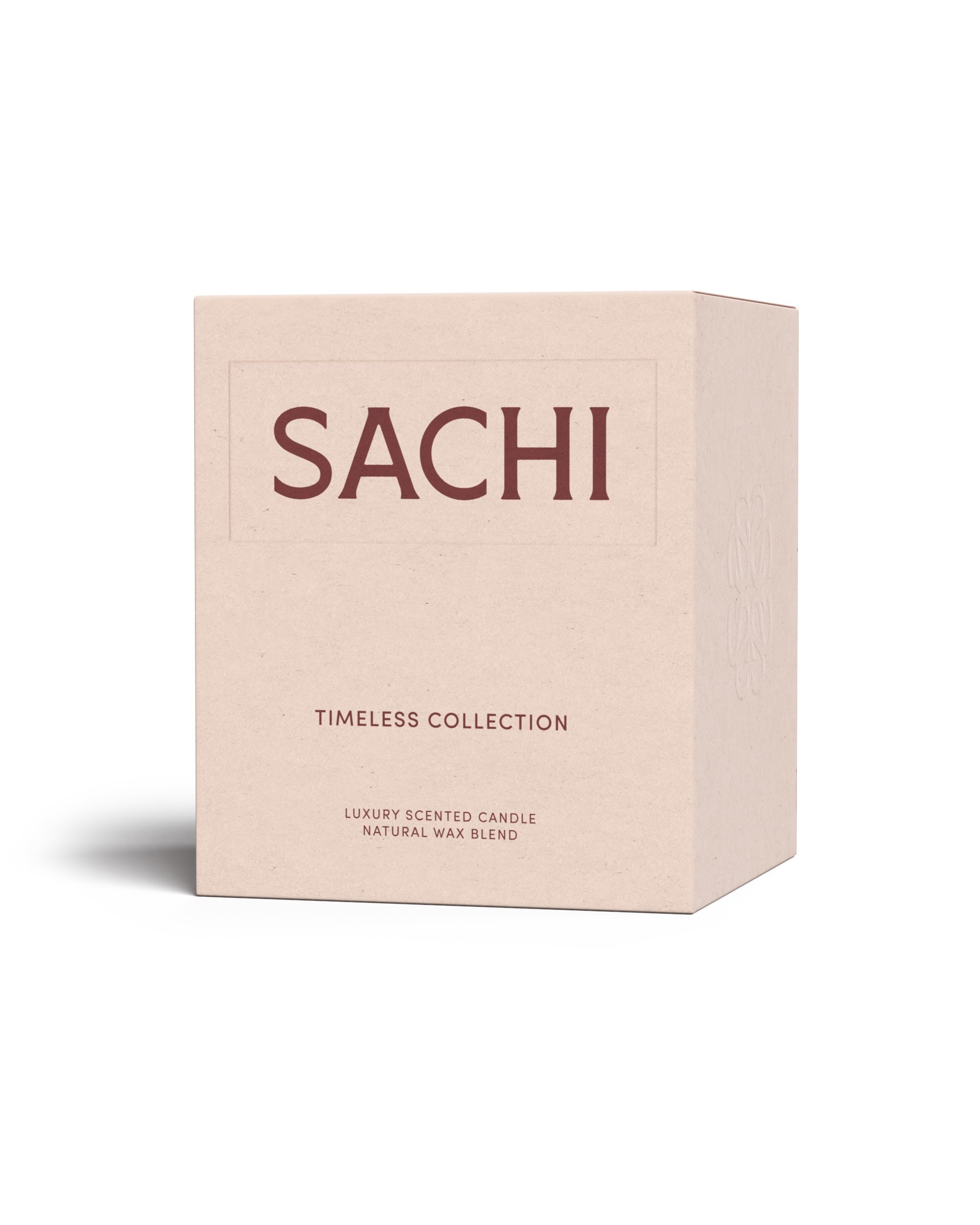 A rectangular cardboard candle box in peach branded SACHI and belonging to the Timeless Candle Collection. On a white background.