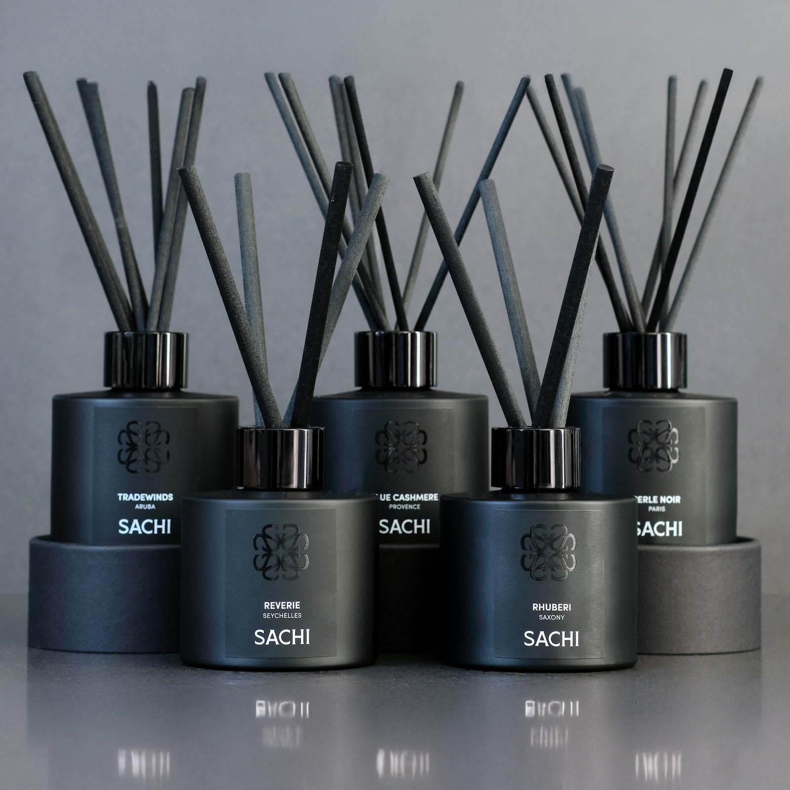 Set of SACHI diffusers with black reeds on a grey background