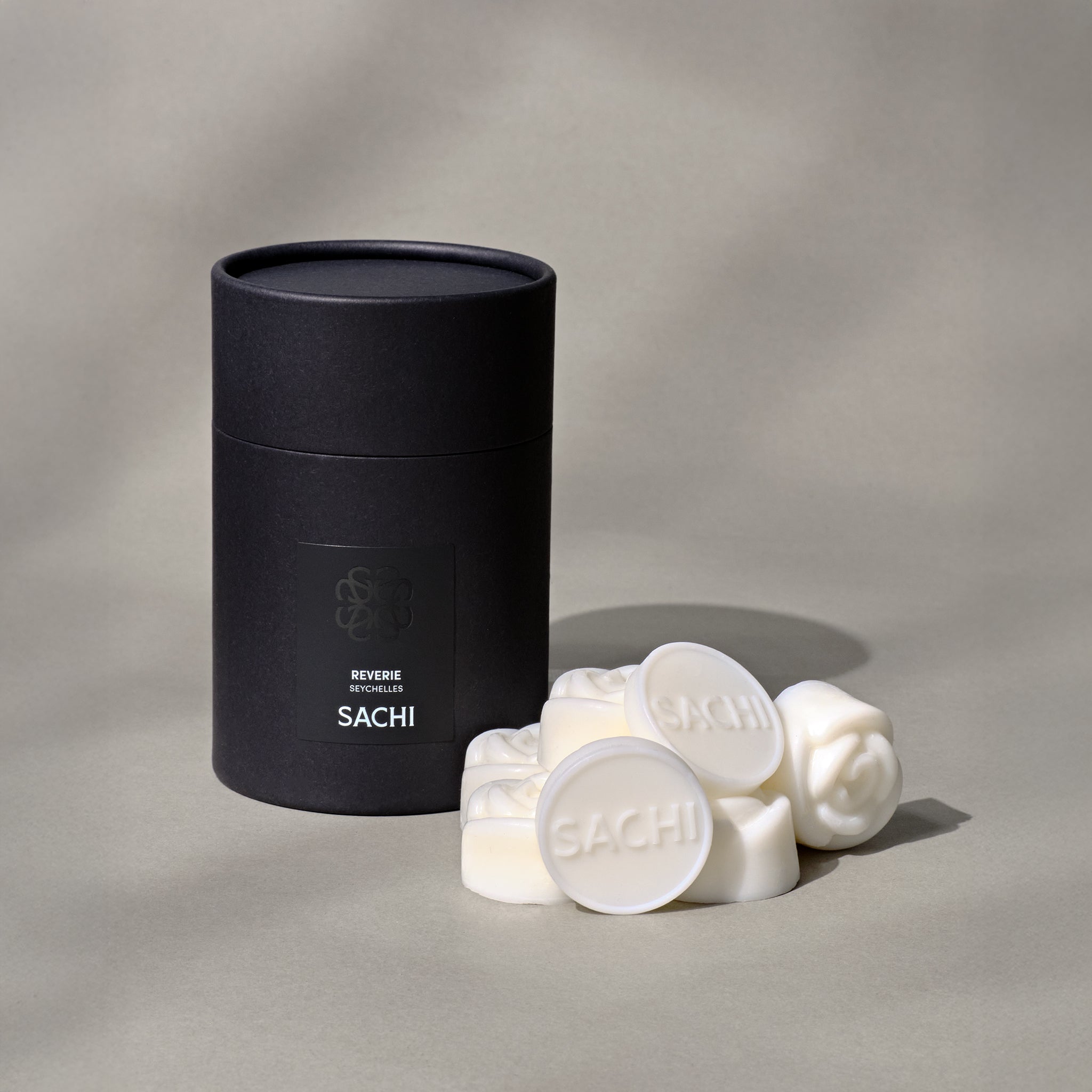 A black presentation box with ivory wax melts on display