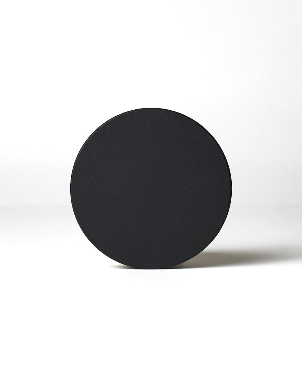 A circular wooden candle cover with visible grain patterns against a white background.