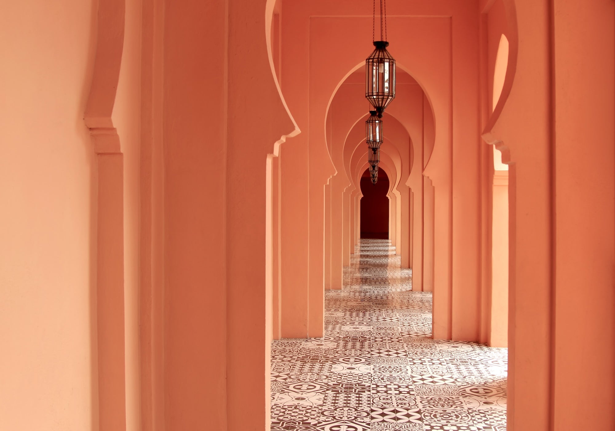 An image of arches in Casablanca. All in orange with a tiled floor.