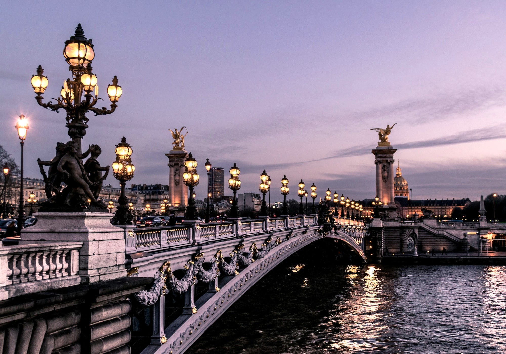 Moody photo of famous bridge in Paris with soft lights.